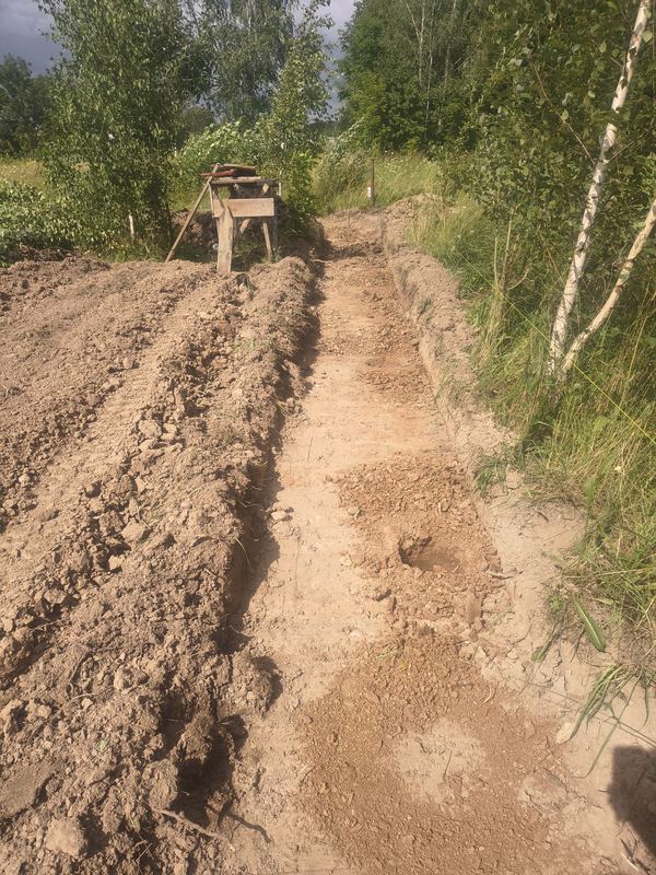 Równy rowek pod podmurówkę ogrodzenia z urobkiem odłożonym wzdłuż wykopu